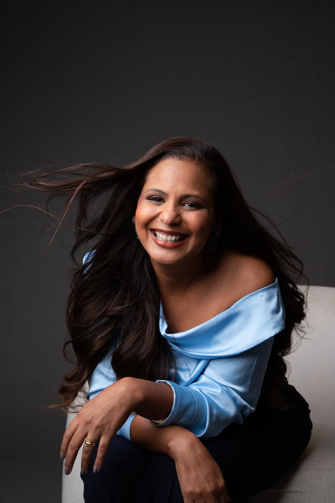 Retrato profissional de mulher sorrindo com blusa azul-clara
